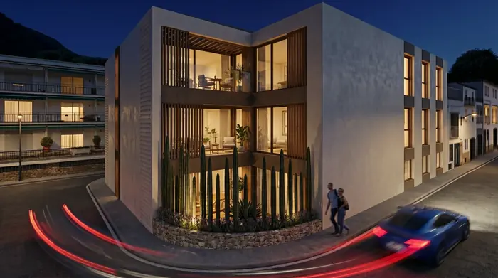 Cantonada de l'edifici al capvespre, amb els habitatges il·luminats
